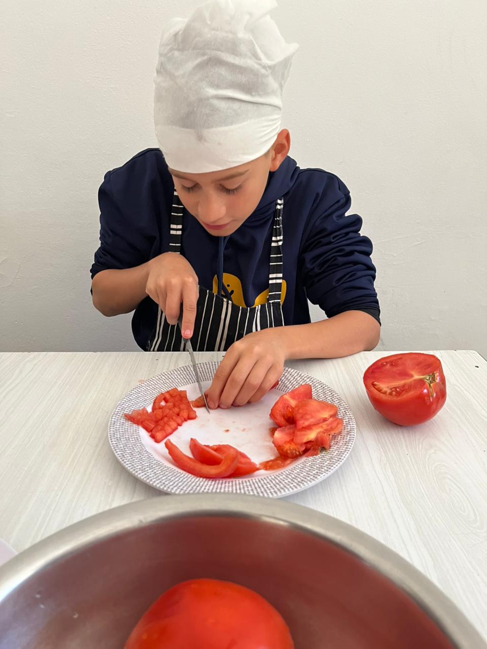 Ein Junge schneidet eine Tomate